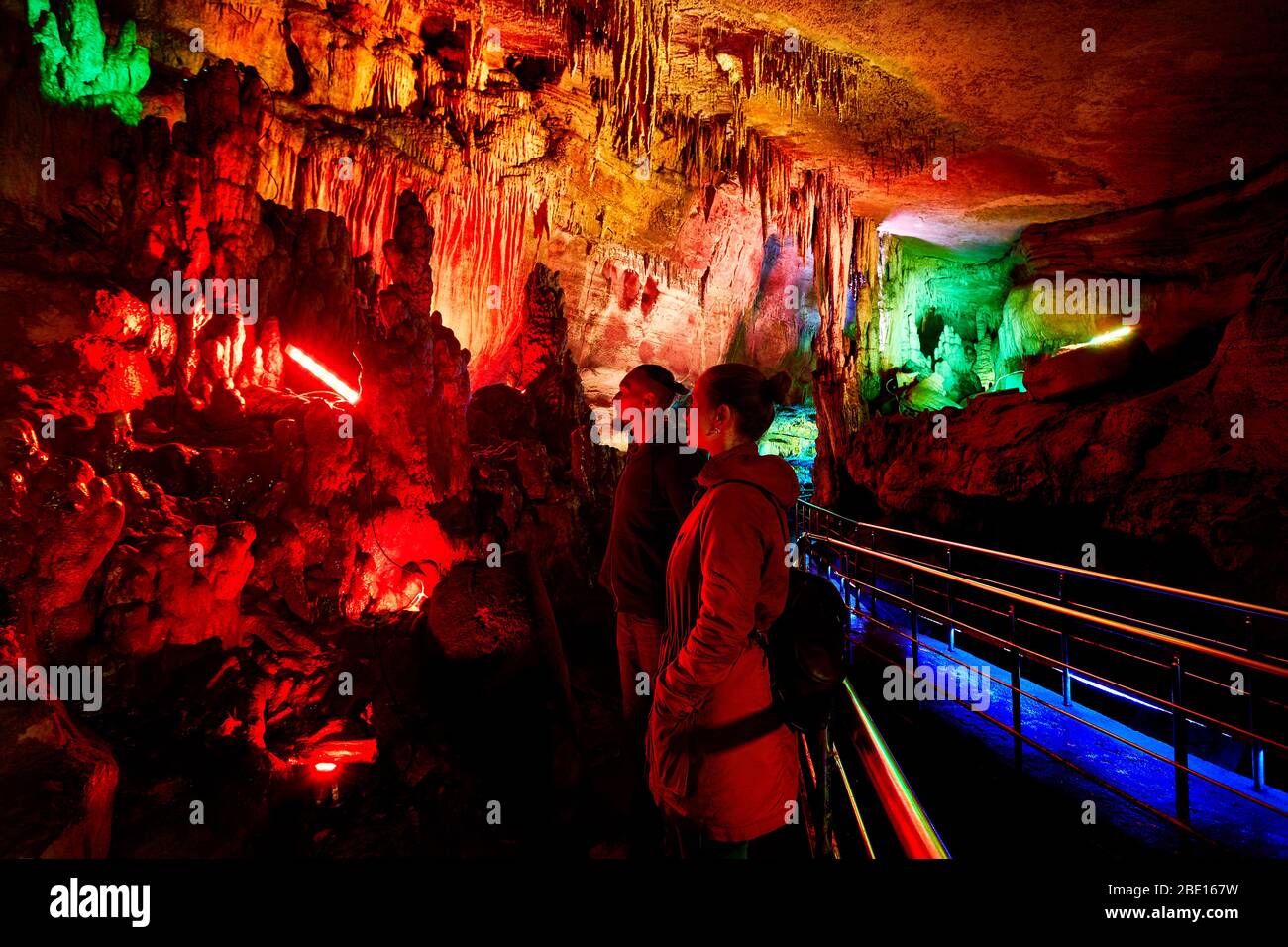Tourist couple in underground cave Sataplia with colorful illumination in Kutaisi, Georgia Stock Photo