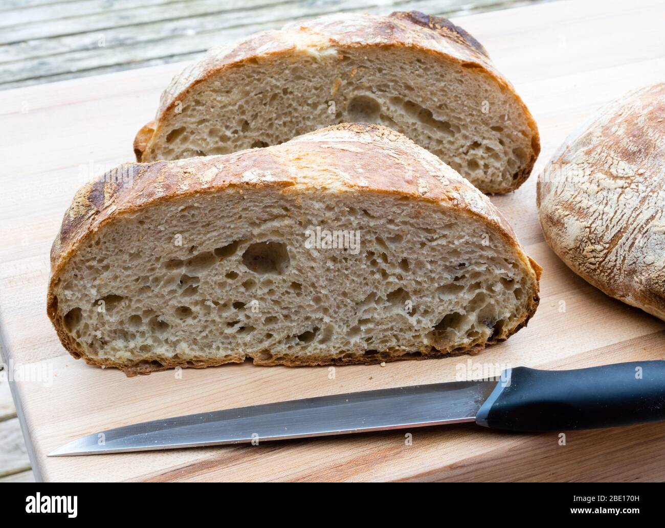 Round french boule bread cut in half with knife Stock Photo Alamy