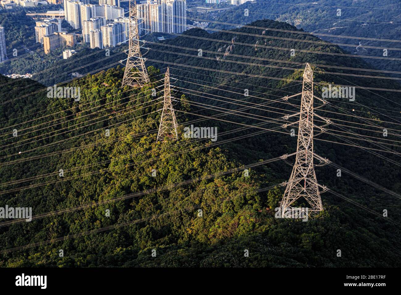 Power tower and power lines crossing over mountains in Hong Kong Stock Photo