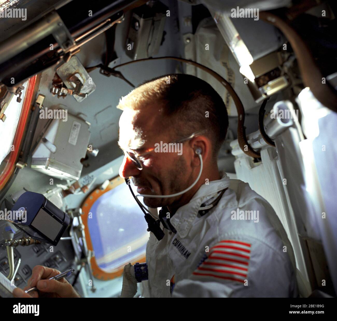 (20 Oct. 1968) --- Astronaut Walter Cunningham, Apollo 7 lunar module pilot, writes with space pen as he is photographed performing flight tasks on the ninth day of the Apollo 7 mission. Note the 70mm Hasselblad camera film magazine just above Cunningham's right hand floating in the weightless (zero gravity) environment of the spacecraft. Stock Photo