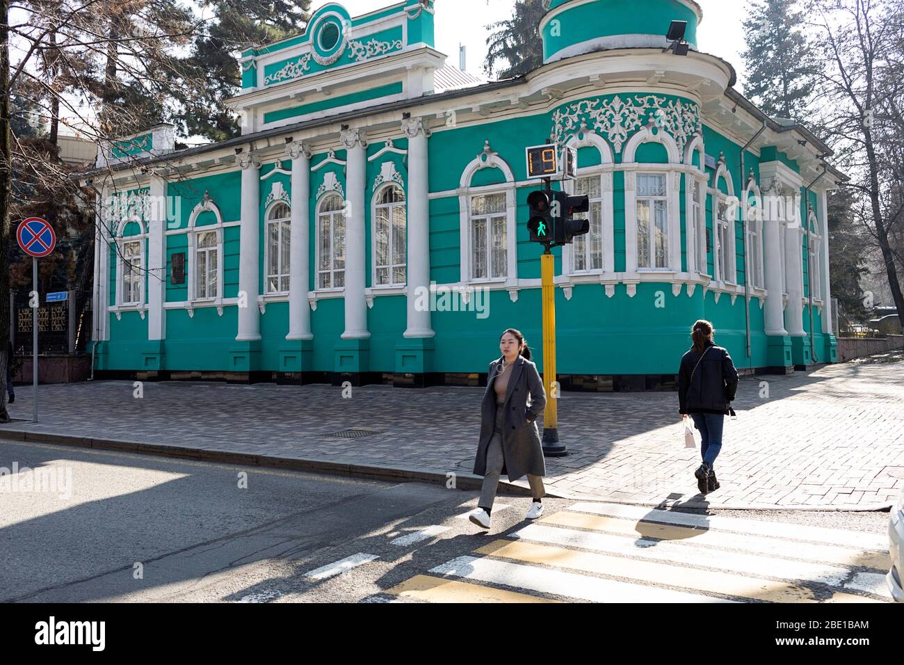 Pedestrians crossing street on green traffic light at old merchant's