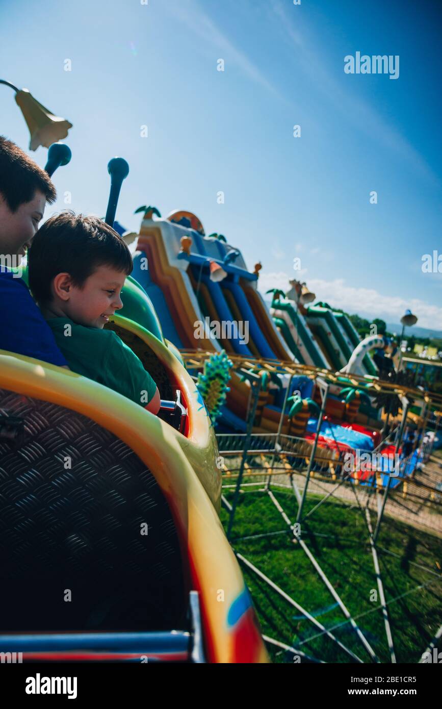 Young happy people having fun and enjoying a roller coaster ride Stock