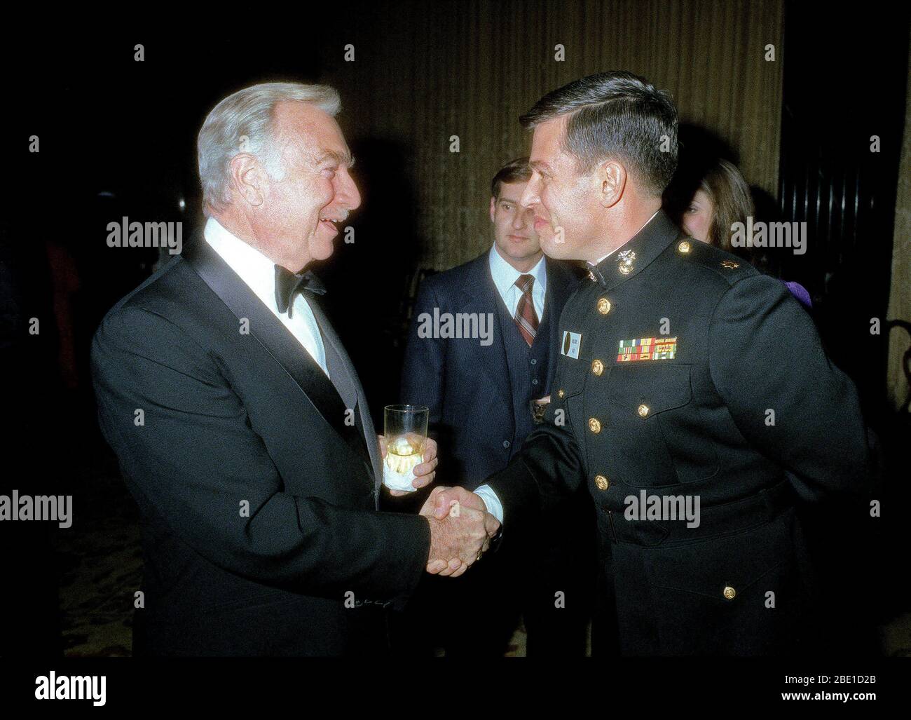 A Marine Corps major shakes hands with Walter Cronkite, the famous radio and television commentator, at the Kennedy Center Inaugural Ball. Stock Photo