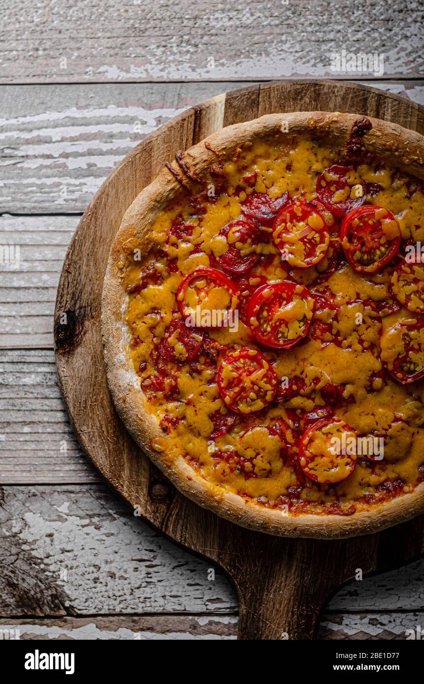 Rustic homemade pizza with sharp cheddar chesse and spicy salami Stock ...