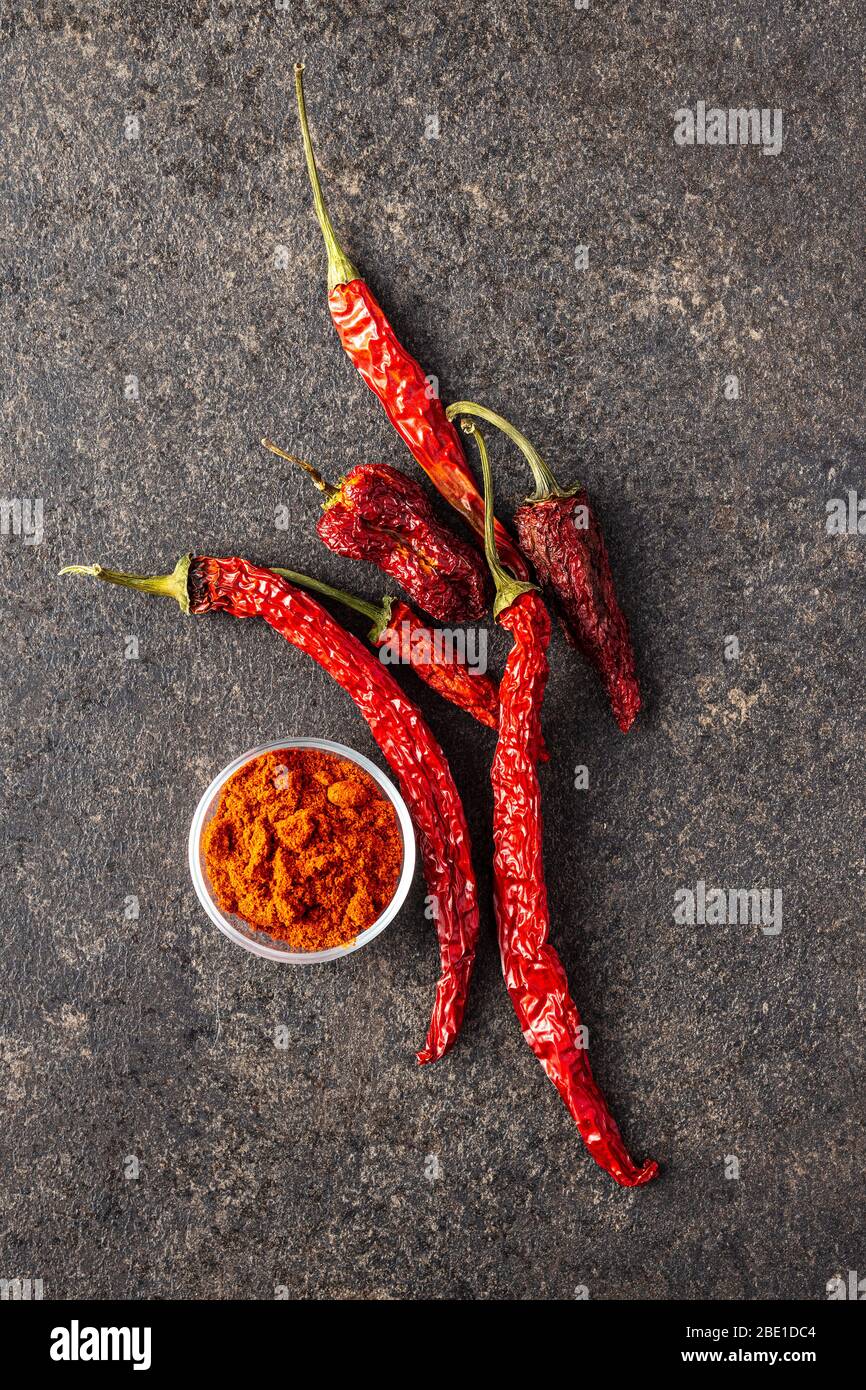Dried red chili peppers and chili powder spice on kitchen table. Top
