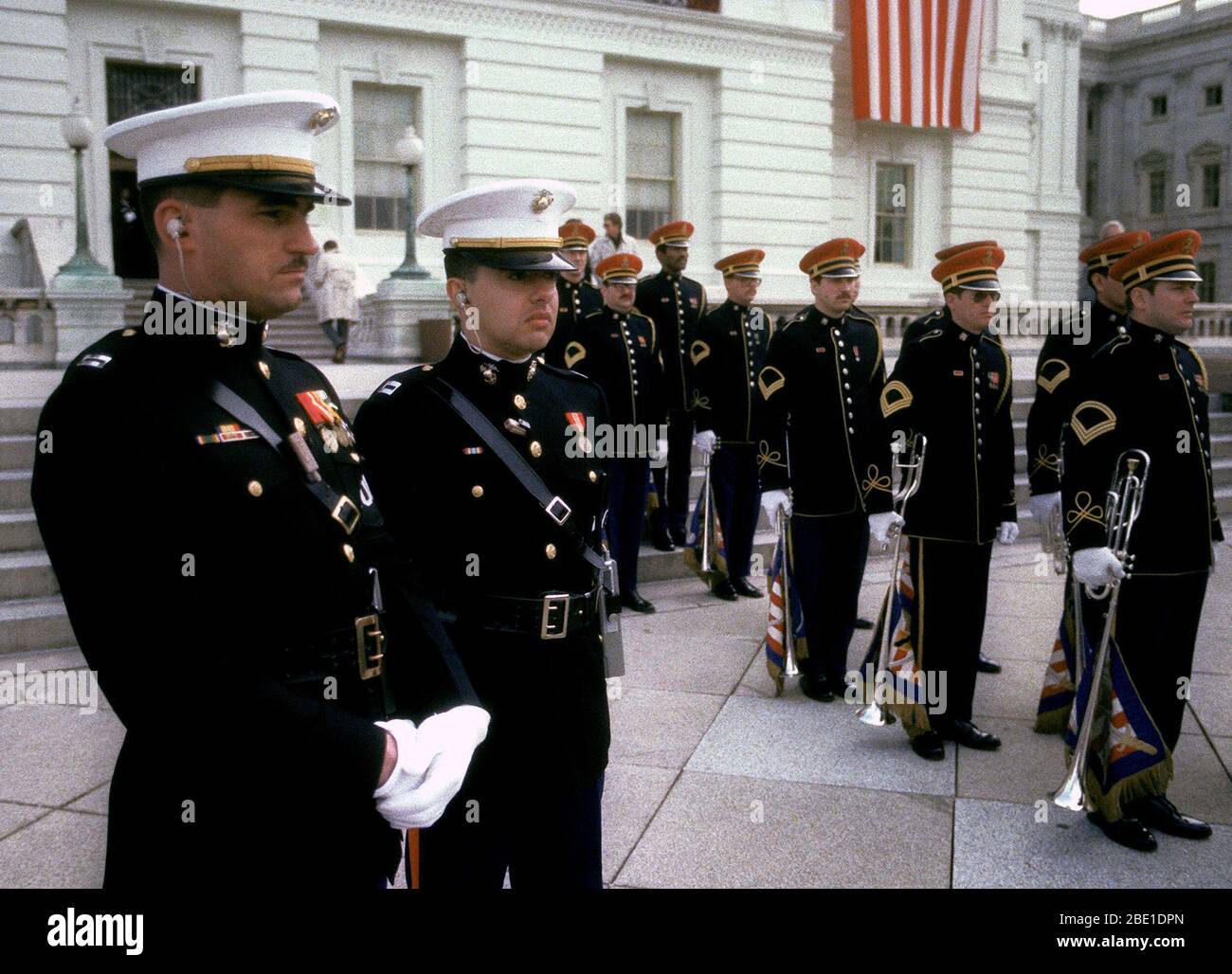 Two Marine Corps captains in full dress blues, wearing the famous Sam Brown belt, watch the U.S. Army Herald Trumpeters get into formation on Inauguration Day. Stock Photo