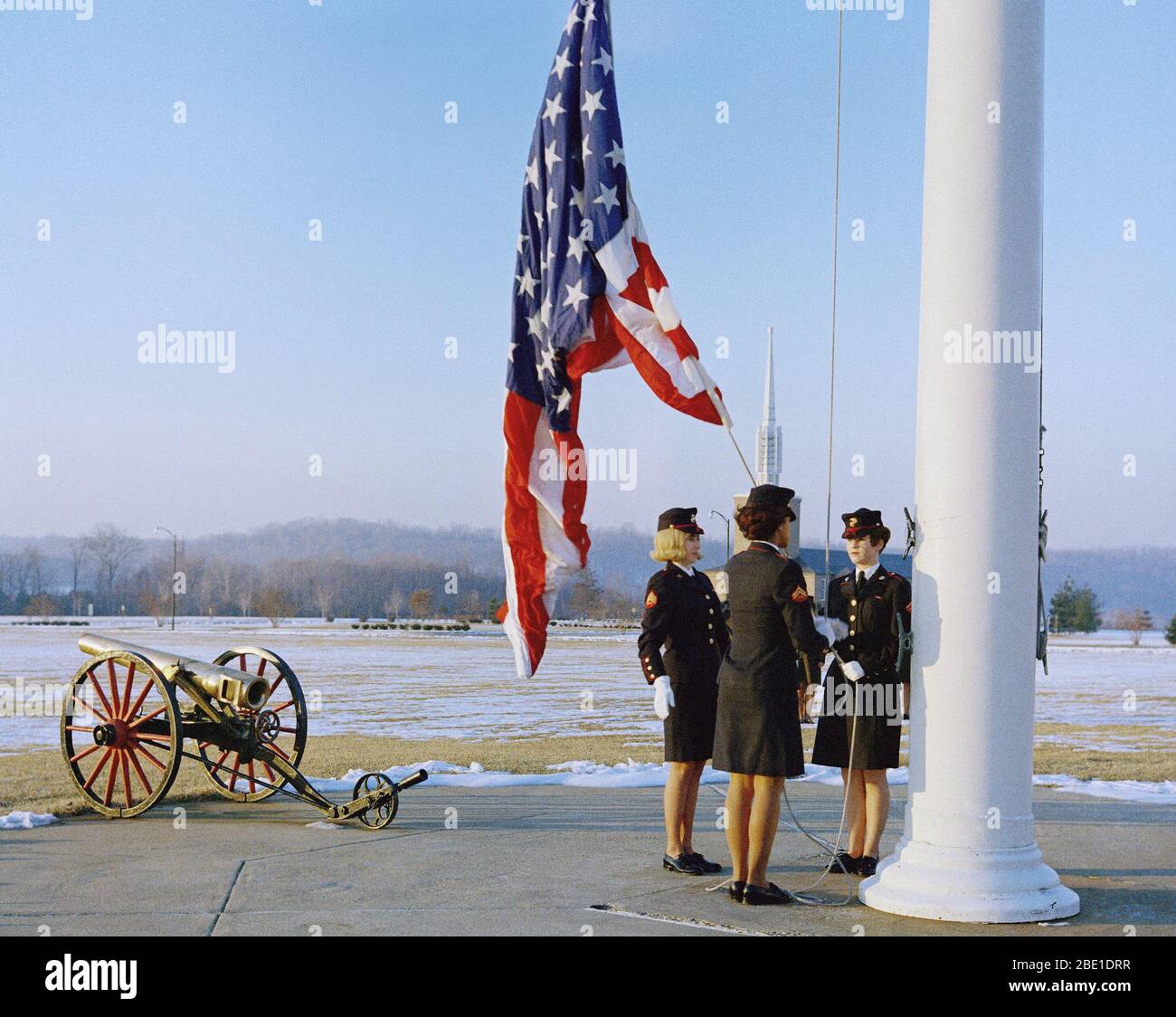 1969 - Three female Marines, in dress blue uniforms, raise the morning colors.  Number three of three. Stock Photo