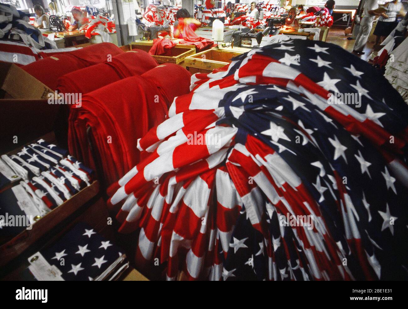 1982 - Recently completed United States flags are stacked in a large ...