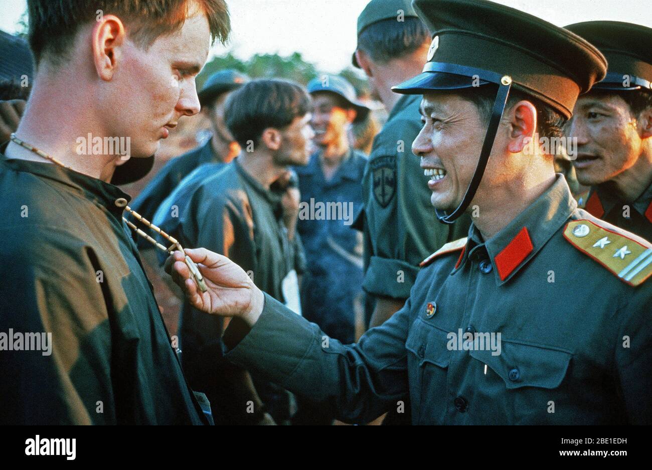 SPC-4 Richard Springman, U.S. Army, Captured 25 May 70) talks with a North Vietnamese Army officer who is looking at his peace symbol.  He is one of the twenty eight American POWs who were released by the Viet Cong on Feruary 12, 1973. Stock Photo