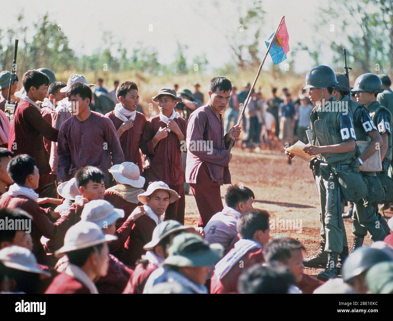 Viet Cong POWs, one with a Viet Cong flag, stand and sit at the exchange location.  They were flown in on USAF C-130 aircraft from Bien Hoa Air Base.  They will be exchanged for American and South Vietnamese POWs held by the Viet Cong forces. Stock Photo