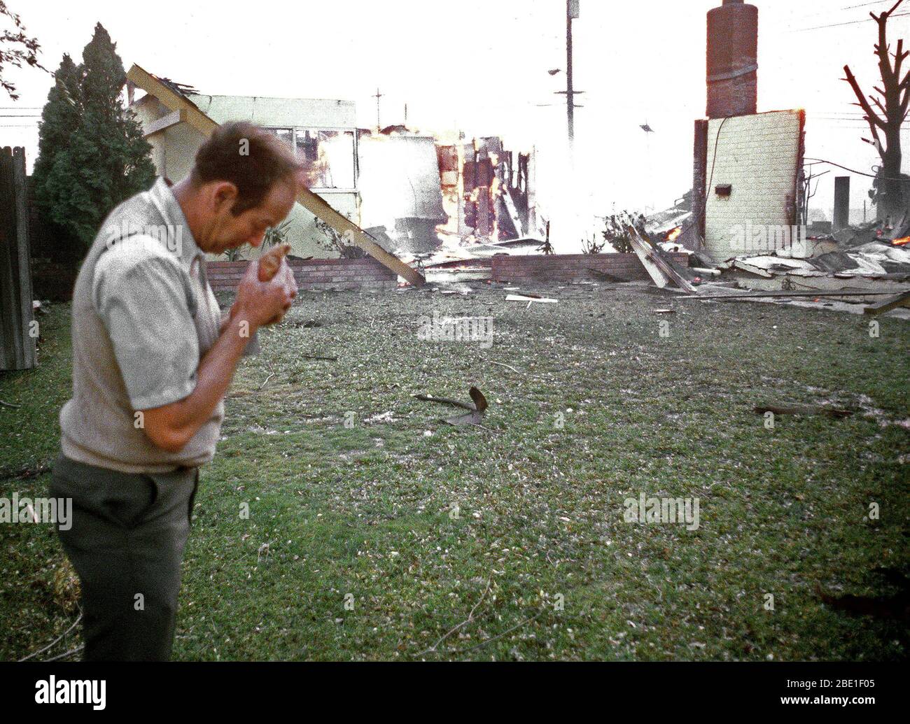 A resident grieves over his home as it is destroyed by flames during the four-day Panorama brush fire, which started in canyons north of town and has been whipped out of control by 40-50 mph winds. Stock Photo