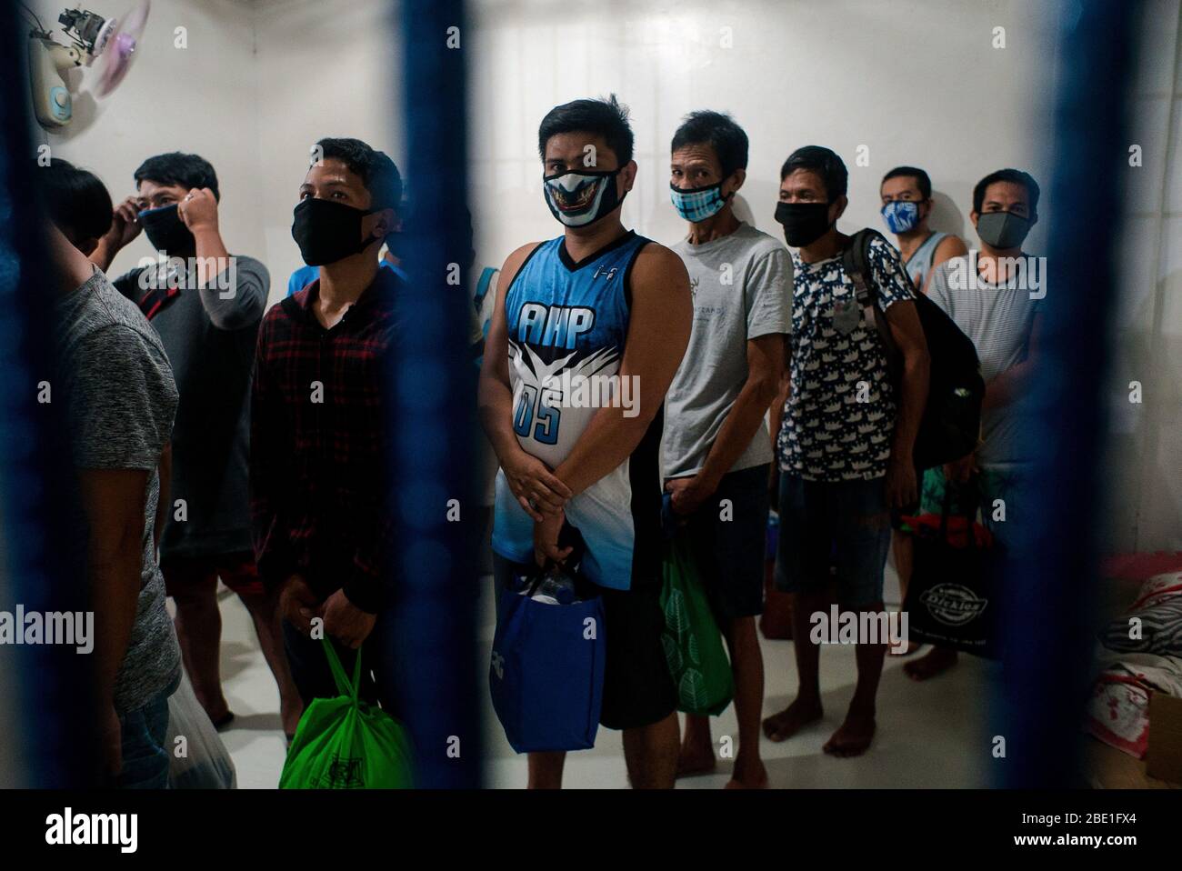 April 6, 2020 - Manila, Philippines: Detainees from Sitio San Roque, Quezon City await to be released on bail from Camp Karingal's detention center on April 6, 2020. Twenty-one residents were arrested for illegal assembly during an emergency health crisis during the enhanced community quarantine in Metro Manila to fight spread of COVID-19. On April 1, 2020, residents of Sitio San Roque gathered together to protest failings of the Duterte administration and local government to provide sufficient relief goods to their community. After a 15-minute warning, the Quezon City Police violently dispers Stock Photo
