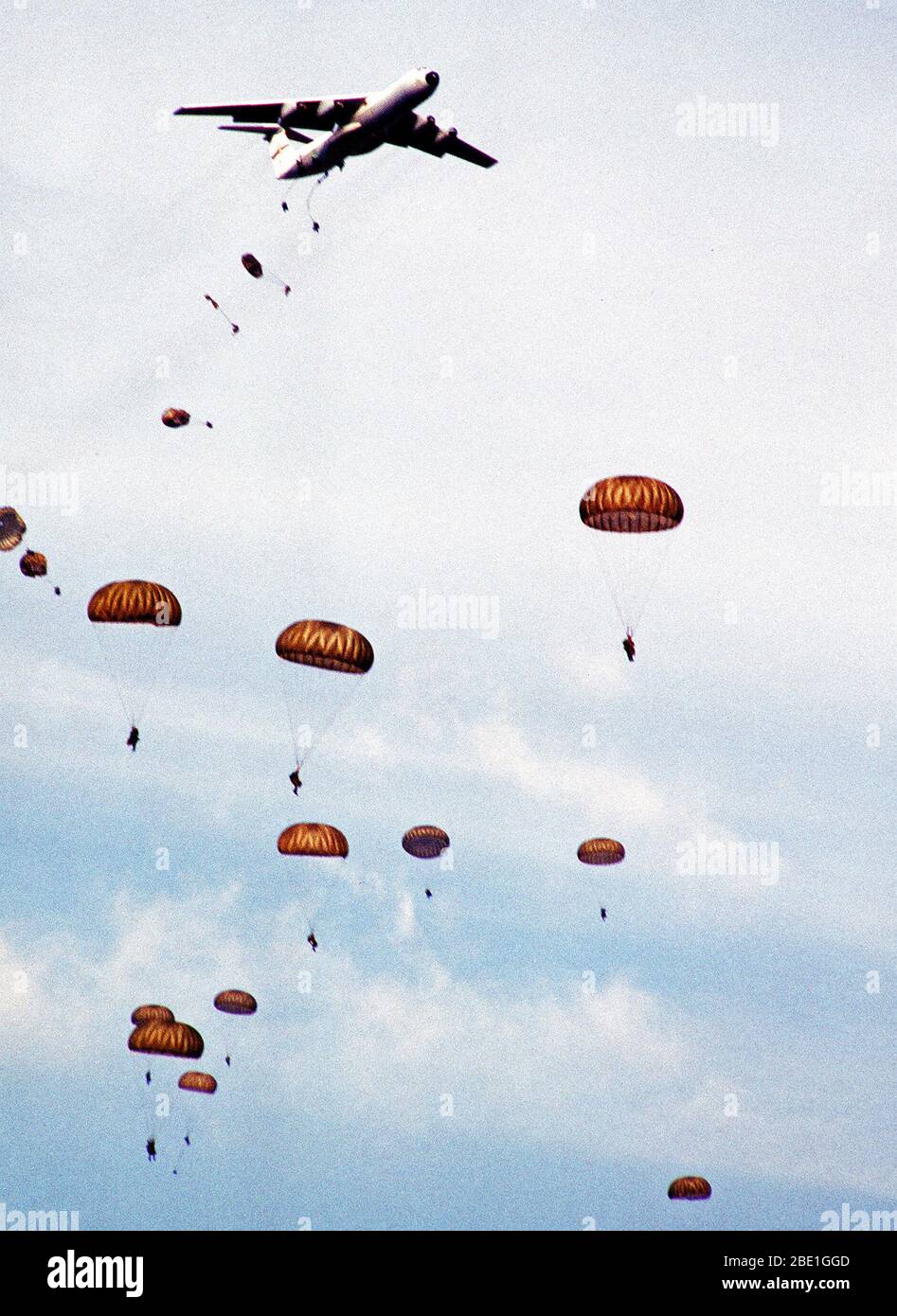 Paratroopers descend from C-141B Starlifter aircraft over Drop Zone B-70 during Dragon Team, the largest non-Joint Chiefs of Staff airdrop training exercise in history. Stock Photo
