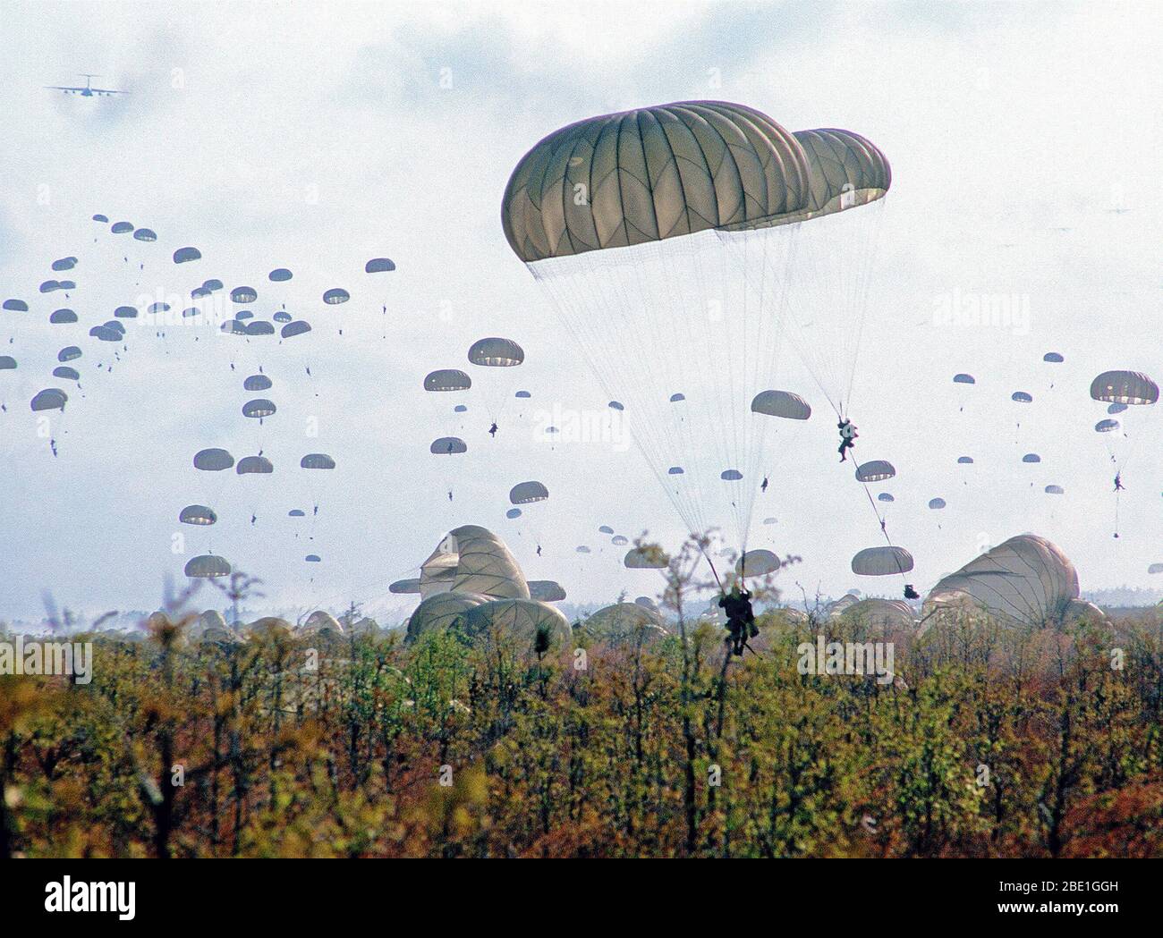 Paratroopers descend at Drop Zone B-70 during Dragon Team, the largest non-Joint Chiefs of Staff airdrop training exercise in history. Stock Photo