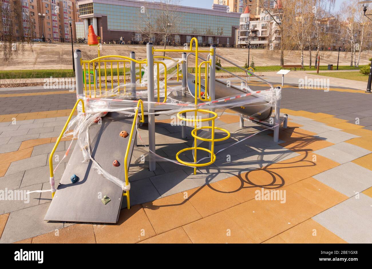 Children's playground, in Kiev, Ukraine, closed due to containment due to a coronavirus outbreak, covid-19. The games are wrapped in cellophane to pre Stock Photo