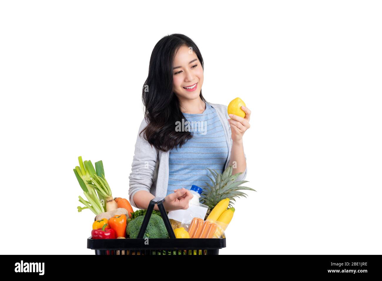 Beautiful Asian woman carrying basket shopping for food and groceries isolated on white background Stock Photo