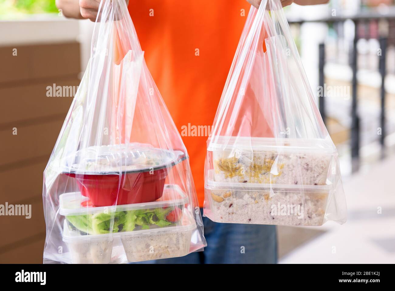 Asian food boxes in plastic bags delivered to customer at home by