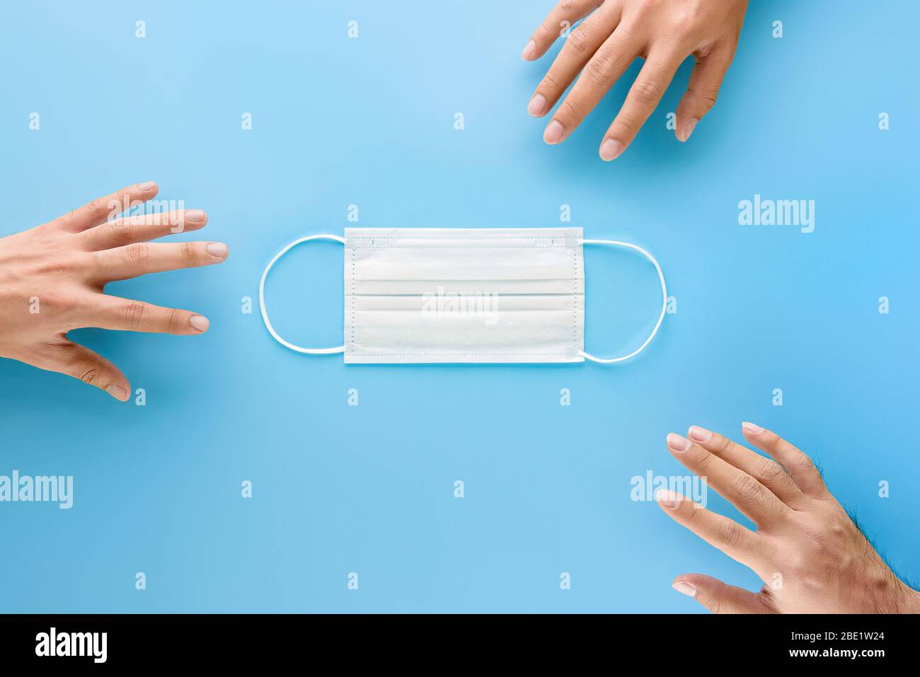 Hands reaching out to get medical face mask to protect from germs and virus during pandemic situation Stock Photo