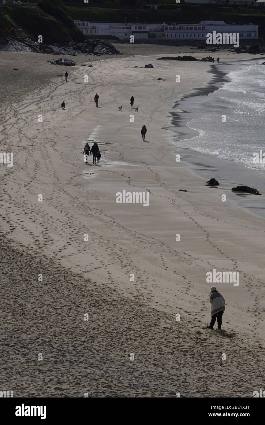 Carona virus precautions Social distancing people walking on beach keeping well apart Portrait format Stock Photo