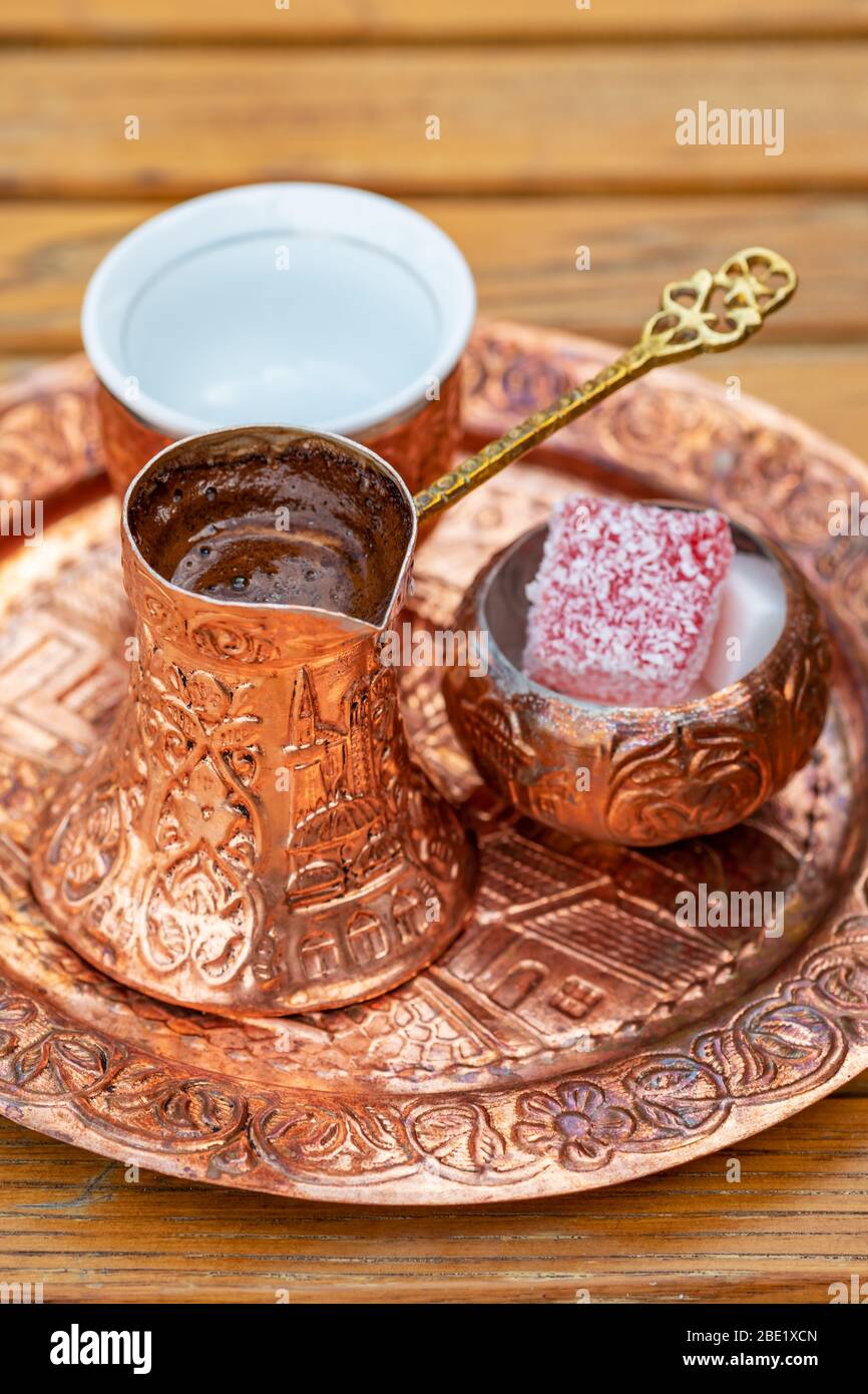 Traditional black bosnian coffee in beautiful copper cezve at wooden table Stock Photo