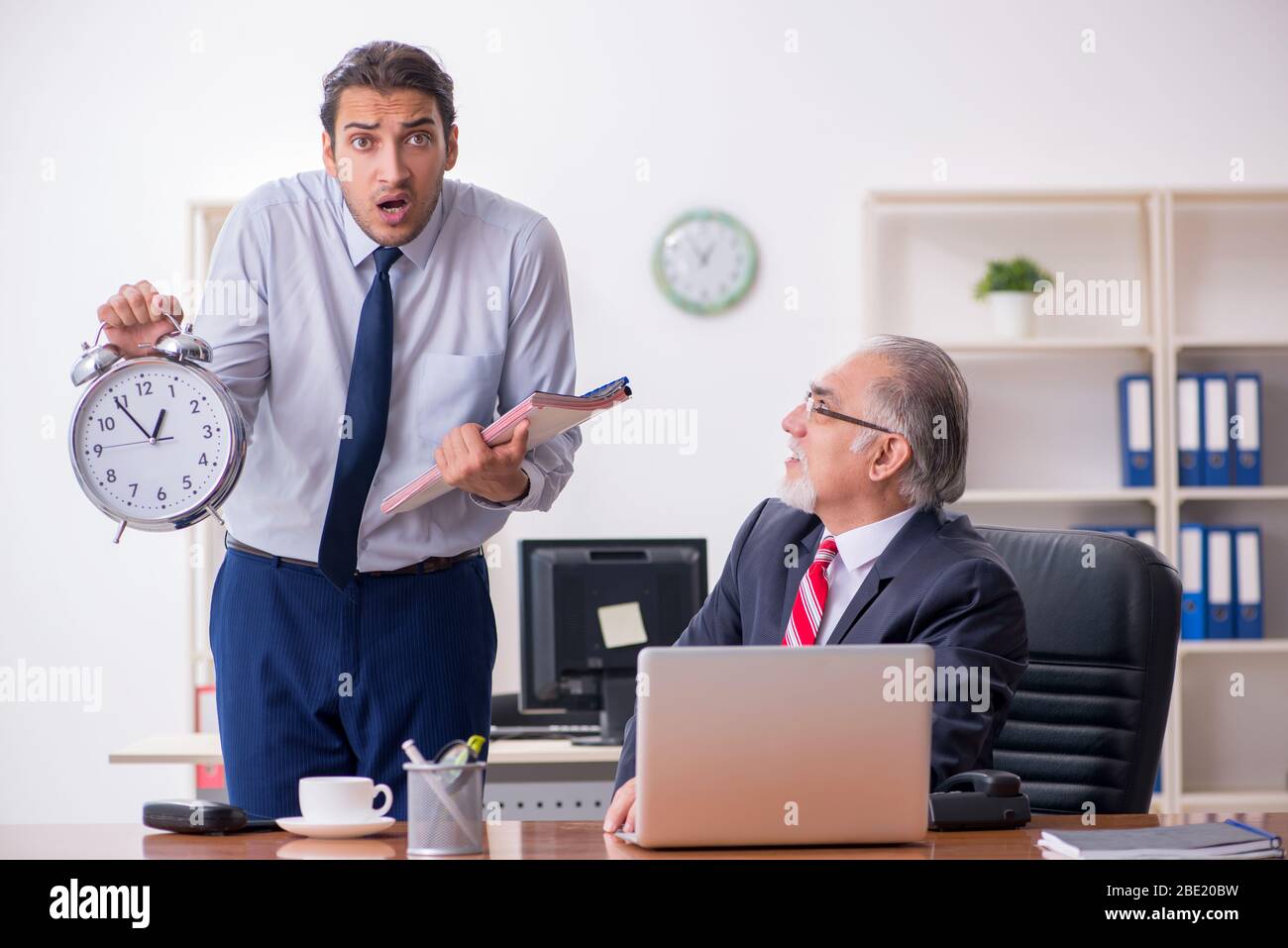 Old boss and young employee in the office Stock Photo - Alamy