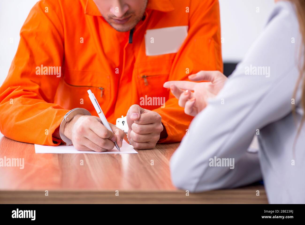 Young man meeting with advocate in pretrial detention Stock Photo