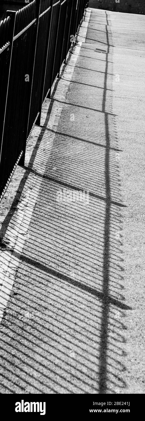 A monochrome image of railings and their shadow. Stock Photo