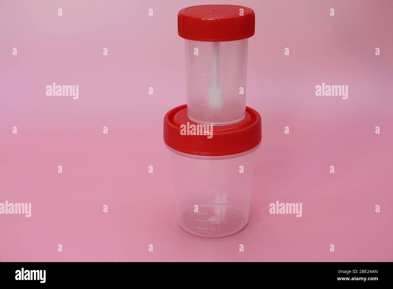 Jars for analysis on a pink background. Containers for feces and urine ...