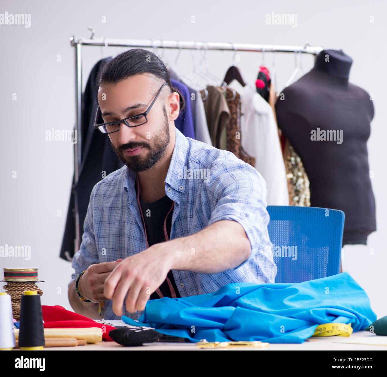 The male tailor working in the workshop on new designs Stock Photo - Alamy