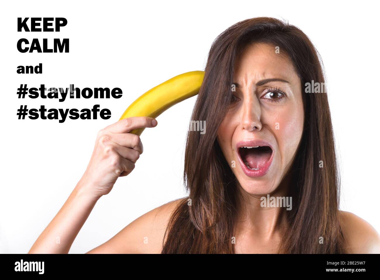 Portrait of a beautiful girl trying to shoot herself with a banana gun, while screaming. With message for COVID-19 alarm, Coronavirus, quarantine and Stock Photo