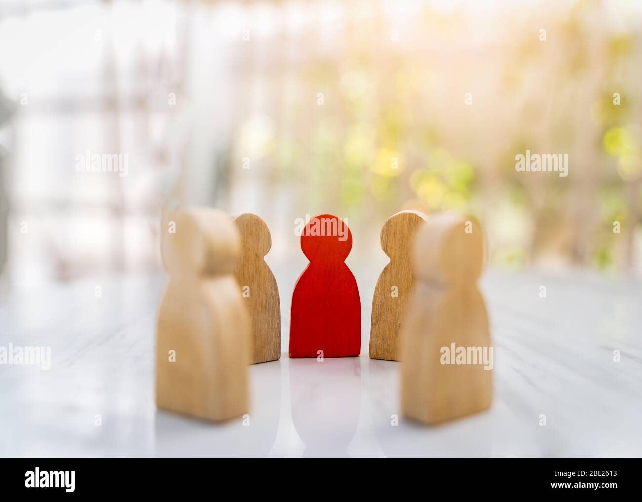 Figure in human resource management concept. The group of wooden puppets is a circular. A red wooden figure like an dominant in a group with blur boke Stock Photo