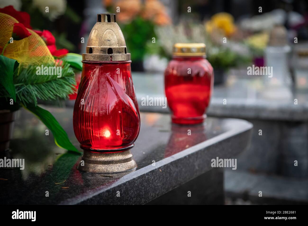 Wroclaw, Poland - 02 November 2019: Red candles on the grave devoted to All Souls Day - Christian holiday of remembrance for the souls of those who ha Stock Photo