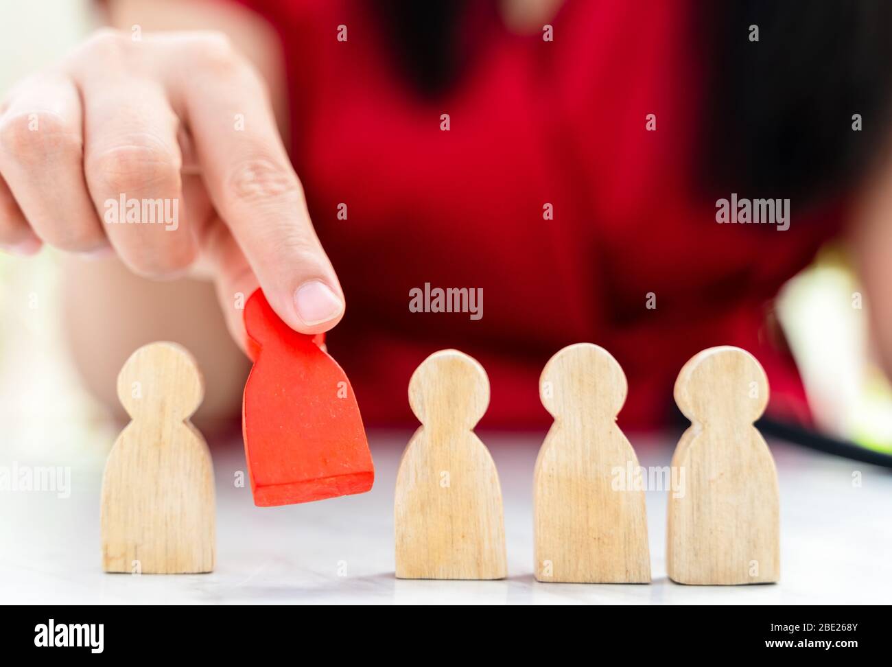 Figure in human resource management concept. The red wood figure was picked out of its group. Red Wood figure like who is selected from the candidate, Stock Photo