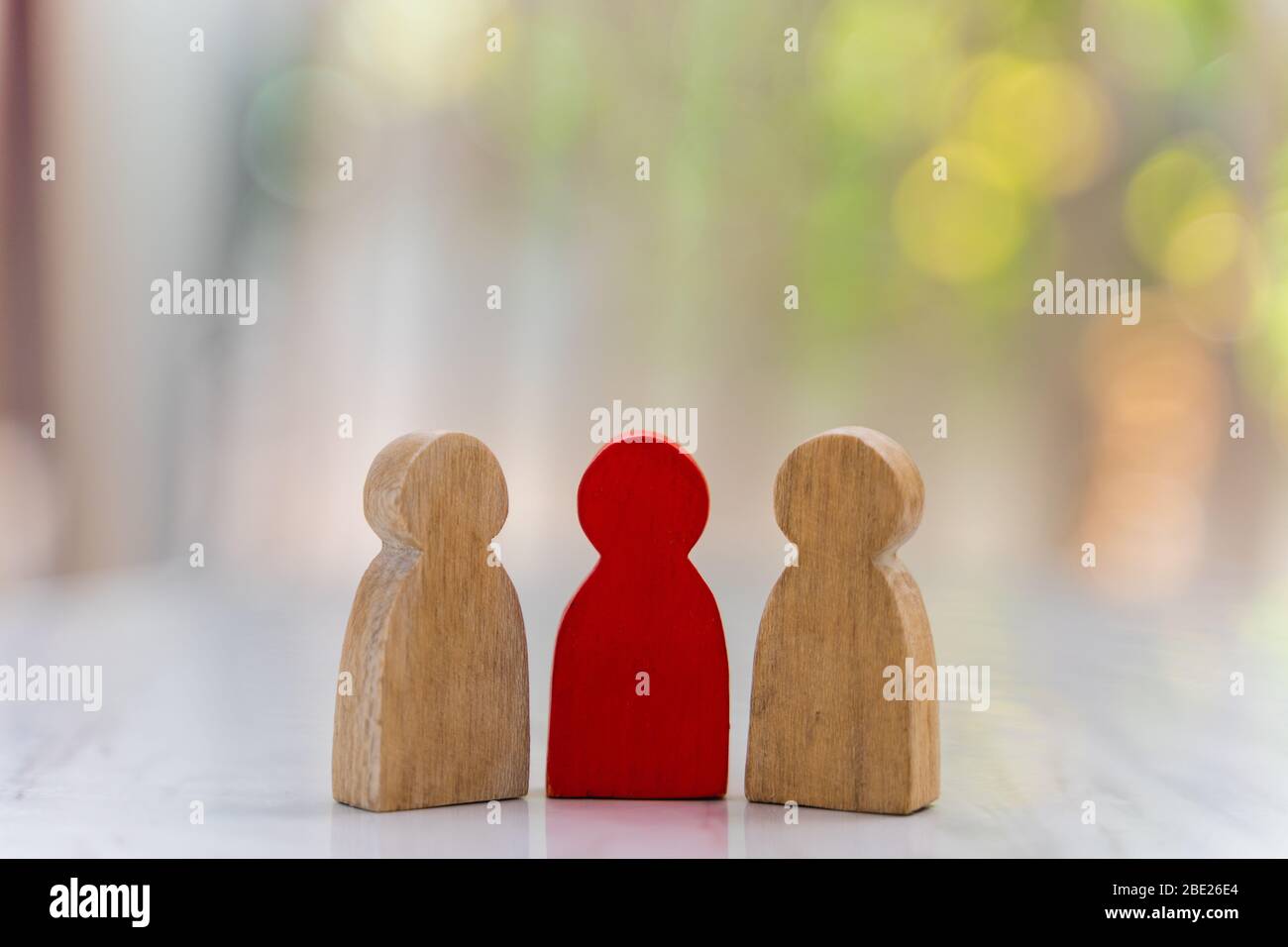 Figure in human resource management concept. The group of wooden puppets A red wooden figure like an dominant in a group with blur bokeh background Stock Photo