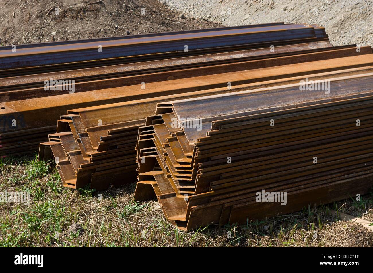 Sheet pile elements stacked and assembled in pairs at a bridge construction site Stock Photo