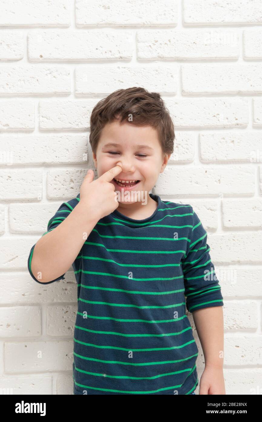 Little boy picks his nose with his finger Stock Photo