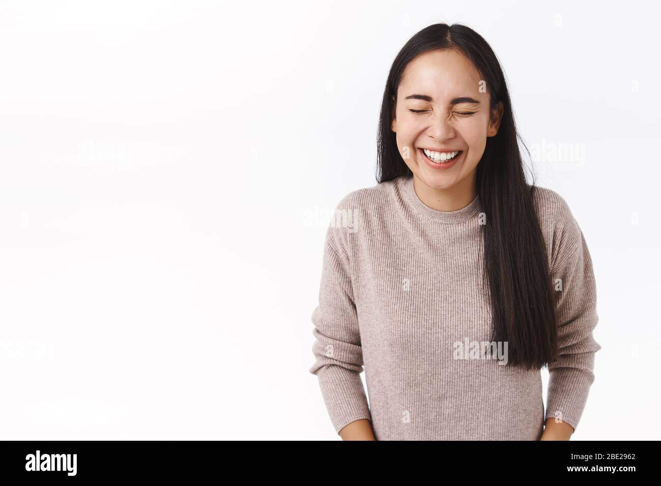Pure emotions, happiness and people concept. Joyful laughing cute east-asian woman with dark long hair, close eyes and chuckling, cant hold laughter Stock Photo