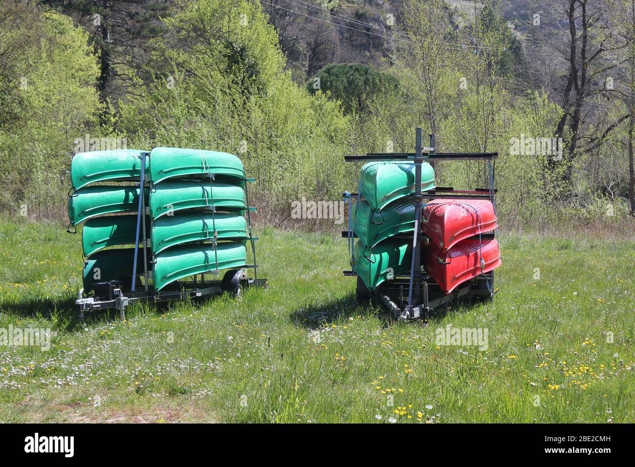 Green and red canoes stacked on two trailers Stock Photo