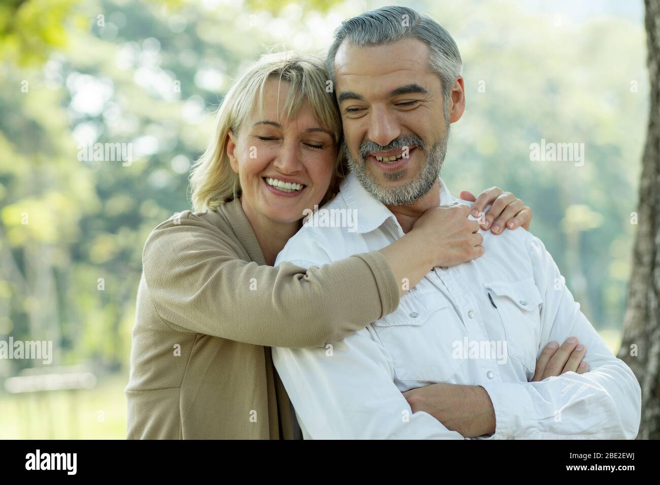Happy senior couple hugging in park in love and romantic Stock Photo ...