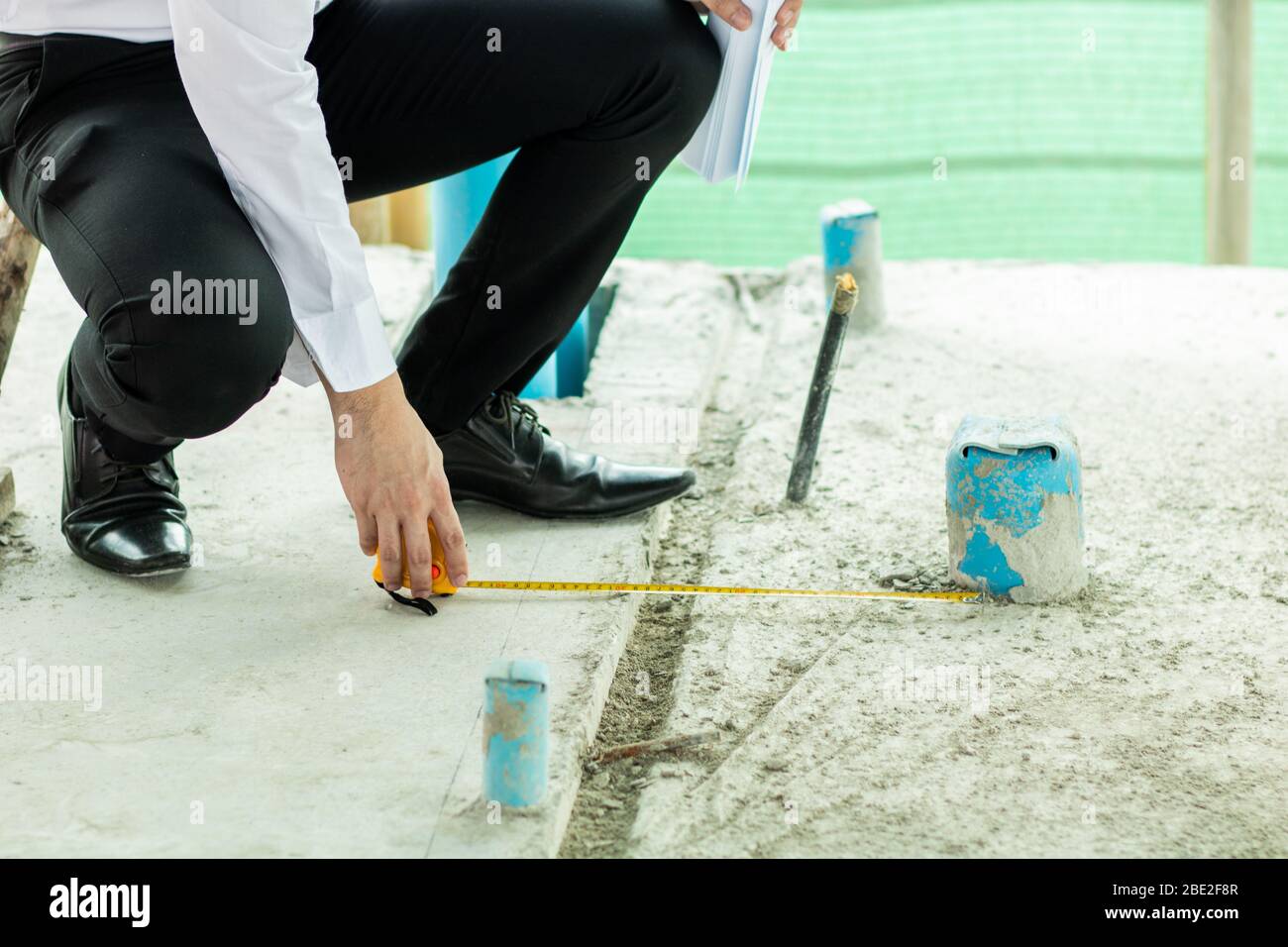 Inspector use measuring tape to check width measurement of drain in building Stock Photo