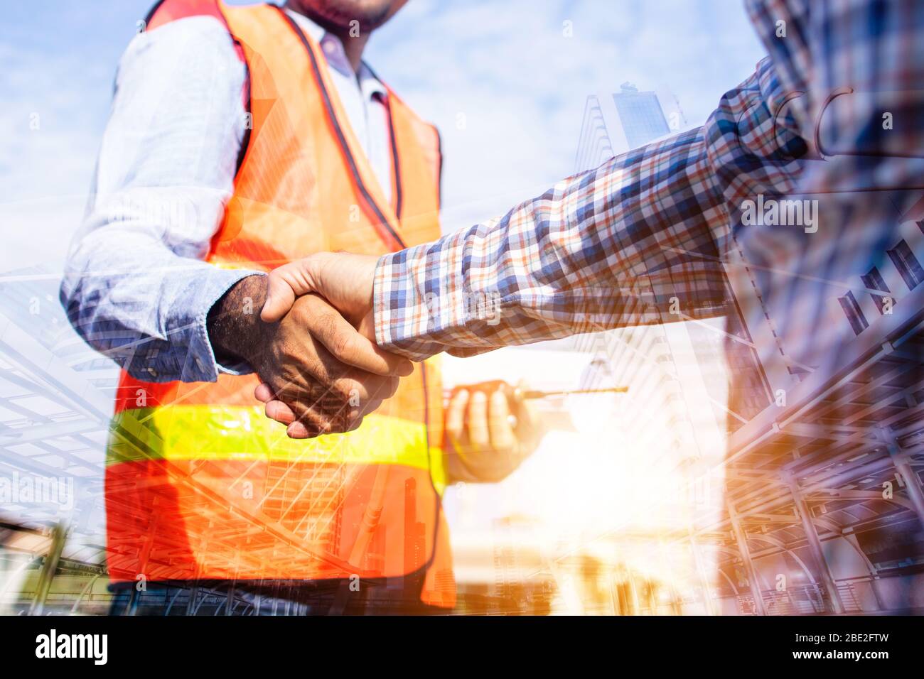 Architect contractor shaking hands with client at construction site Stock Photo