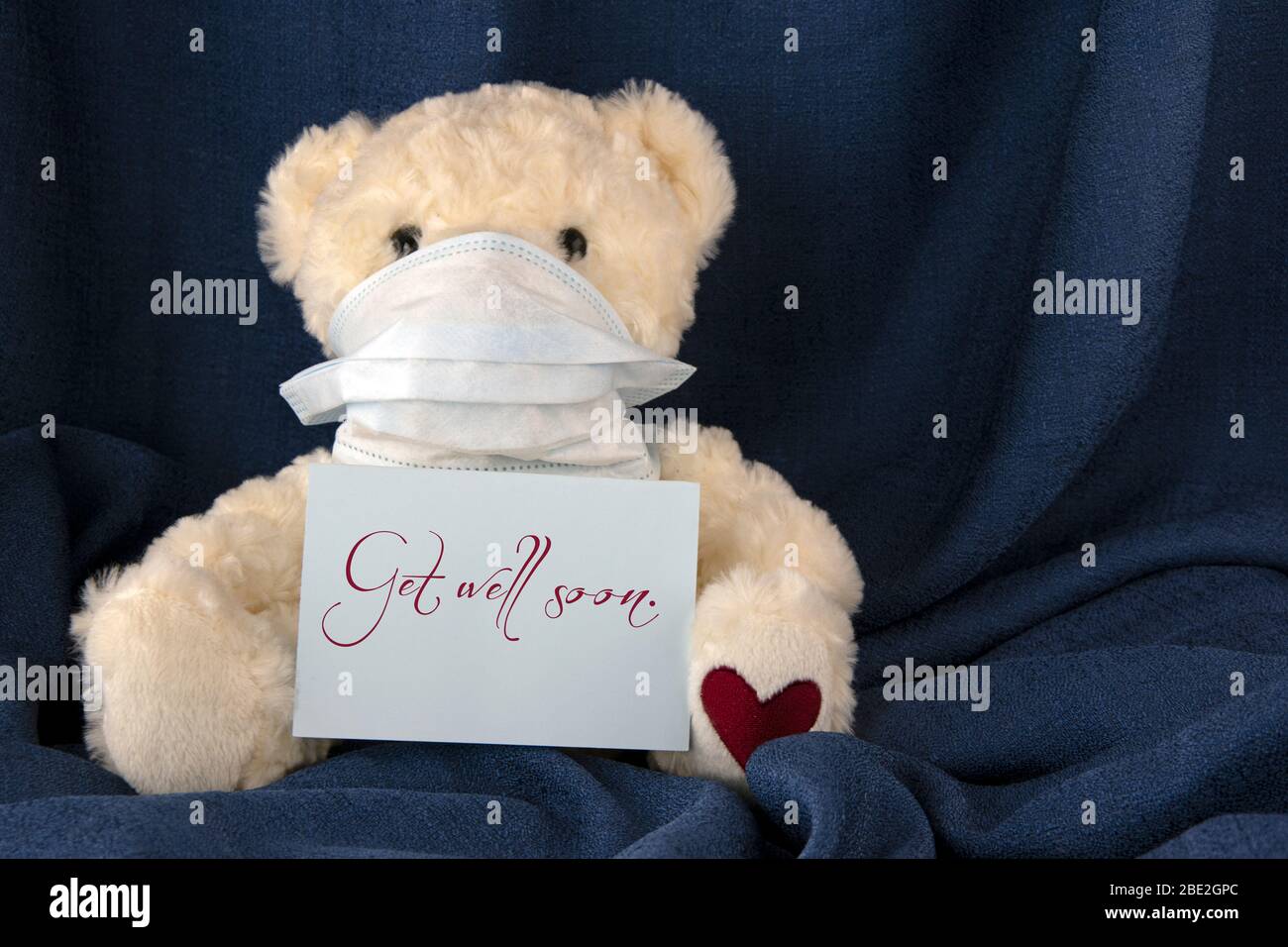 Teddy bear with facemask, blue cloth background, words GET WELL SOON Stock  Photo - Alamy