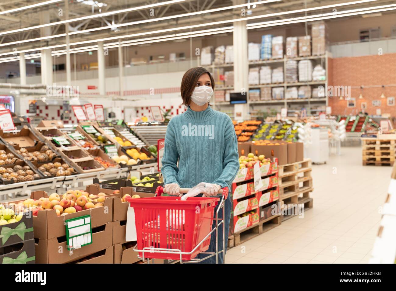 Girl in medical mask makes stock products market Stock Photo - Alamy