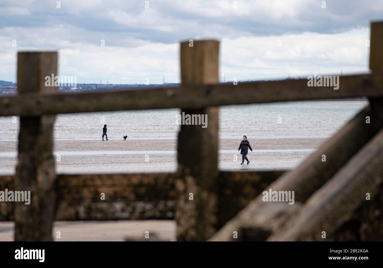 Portobello, Edinburgh. Scotland, UK. 11 April, 2020. On Easter weekend Saturday morning the public were outdoors exercising and walking on Portobello beach outside of Edinburgh. The popular beach and promenade was very quiet and people were exercising proper social distancing.  Iain Masterton/Alamy Live News Stock Photo