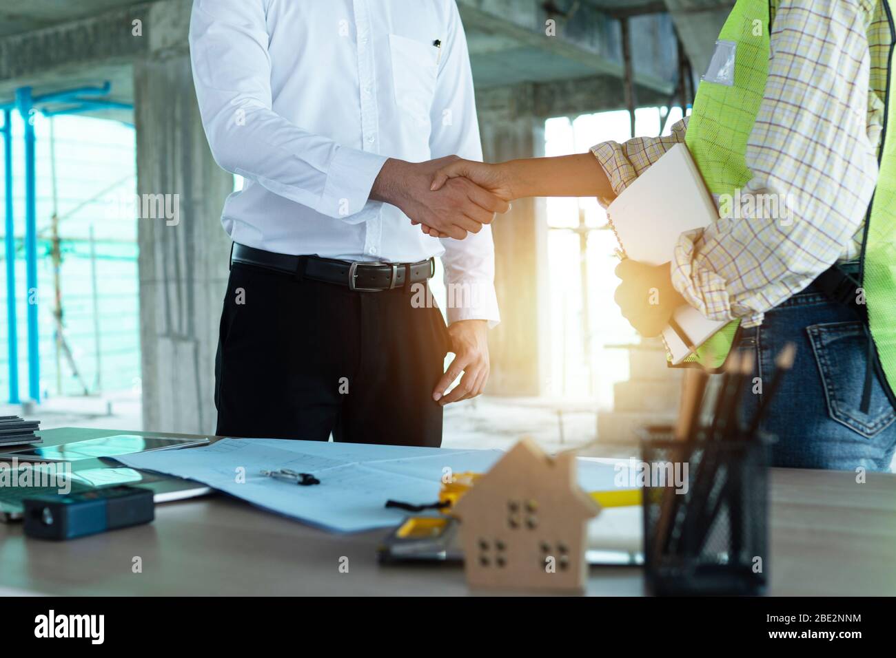 Negotiation Engineering Close up engineer shaking hand with business man in construction site ...