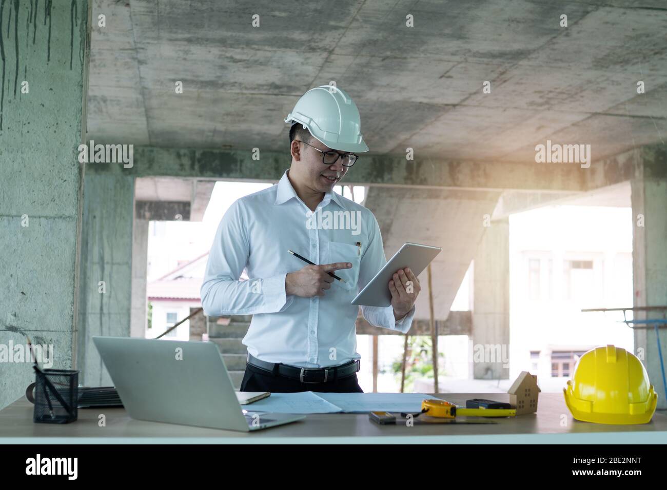 Engineer working with taplet and laptop on wood table in construction site, engineering technology concept Stock Photo