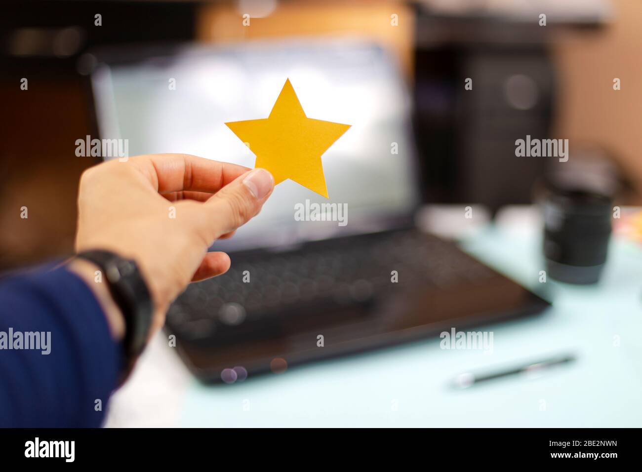 Person holding a five star paper, excellent rating. Feedback, Rated, Customer Experience Concept Stock Photo