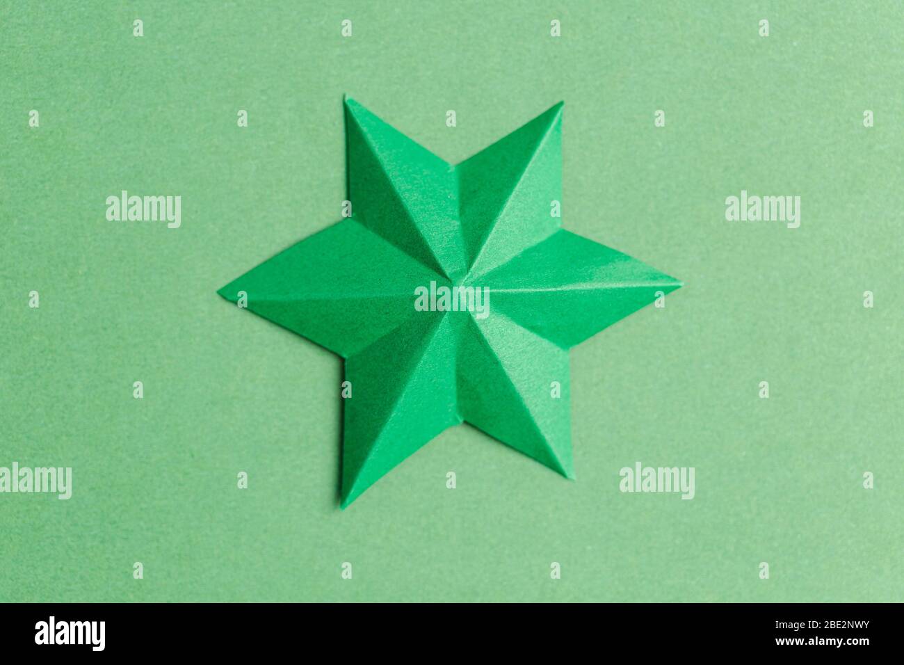Green paper star over green background Stock Photo