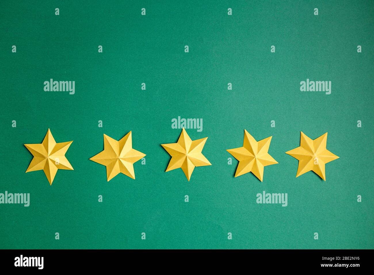 Yellow star paper over green background, five star rating concept. Feedback, Service rating, satisfaction concept, place for text. Stock Photo