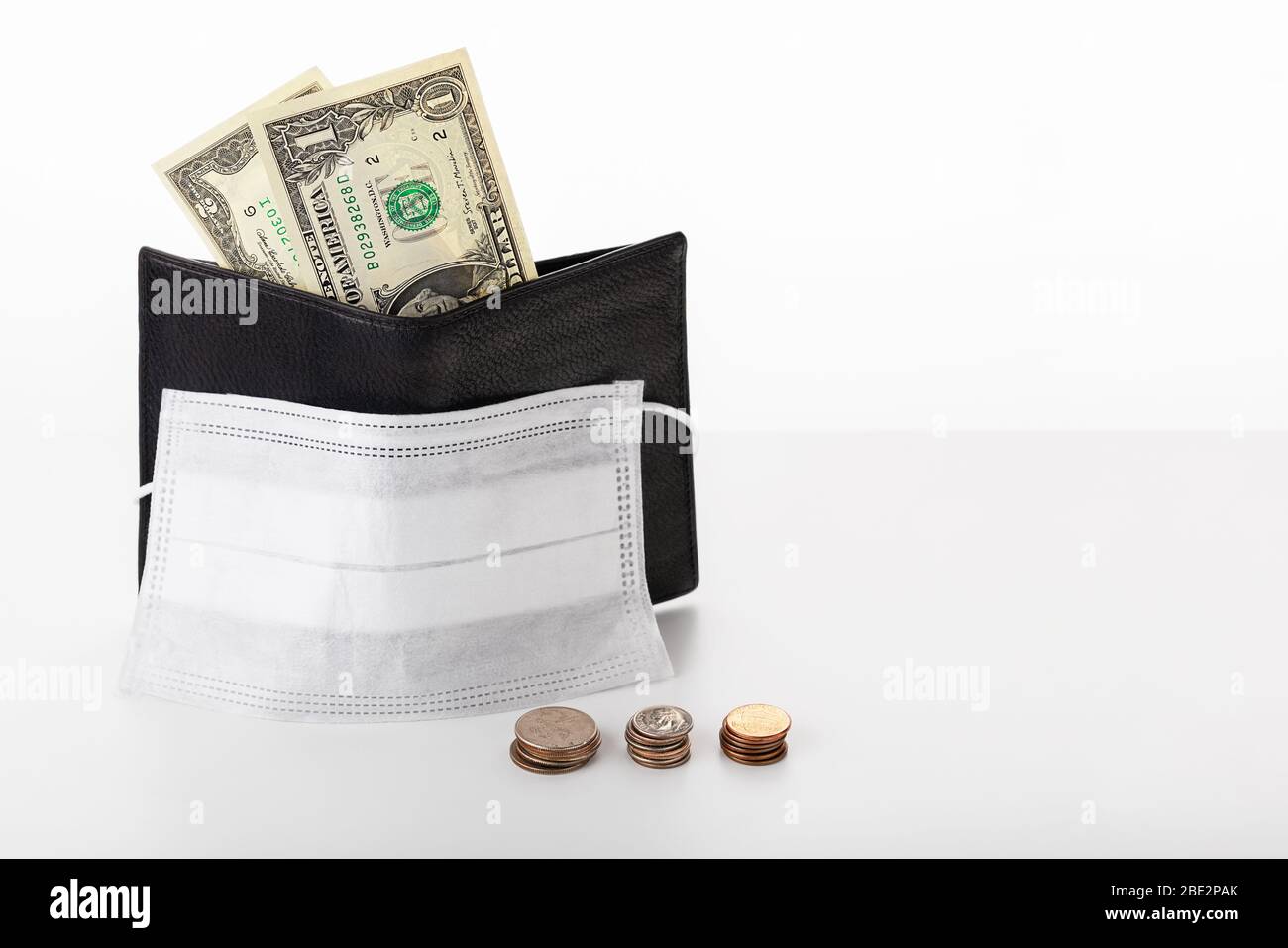 Wallet with dollar, cents and a protective mask isolated on white background. Concept of a global crisis and falling incomes  due to pandemic coronavi Stock Photo